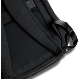 A black backpack featuring padded straps and a sleek design, with a discreet logo on the fabric.