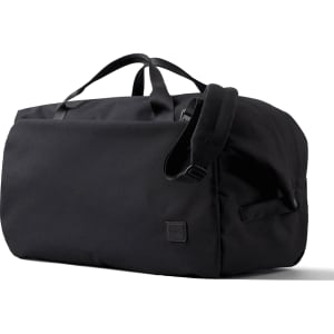 A black duffel bag with handles and an adjustable strap, featuring a small logo on the side.