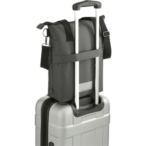 A black laptop tote made from recycled material, sitting atop a silver suitcase with extending handles.