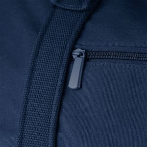 A close-up of a navy blue duffel bag featuring a zippered pocket and textured fabric. It has a logo present.