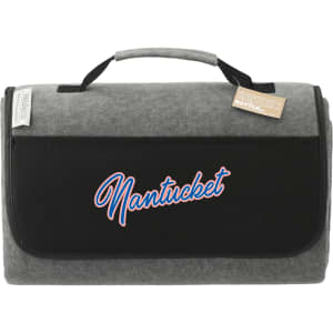 A grey picnic rug with a black flap and a logo. It features a handle for easy transport.
