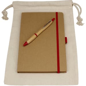 A drawstring bag in natural colour containing a brown journal book with a red elastic band and a red pen.