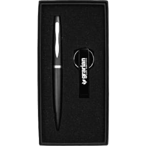 A black pen and bottle opener keyring set nestled in a black gift box with a branded logo.