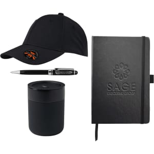 A black cap, black pen, black candle, and black notebook, all featuring branding elements.