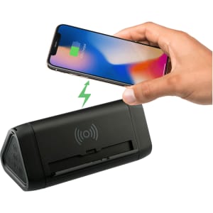 A black power bank with wireless charging feature, paired with a smartphone displaying a charging indicator.