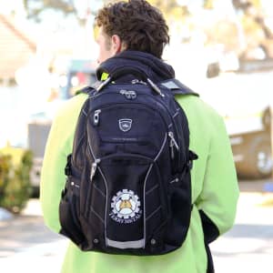 A black High Sierra Elite Fly-By 17" 42L computer backpack with a logo, worn by a person facing away.