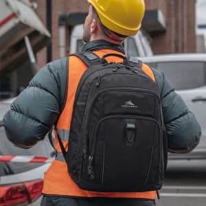 A black High Sierra Extension Backpack with multiple compartments, worn by a person in a reflective vest and hard hat.