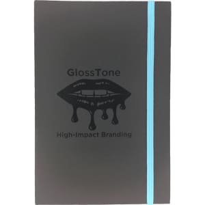 A black journal with a turquoise elastic band and a glossy lip graphic. It features a logo but no text.
