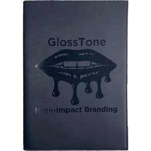A black refillable journal with a glossy lip graphic and branding on the front cover.