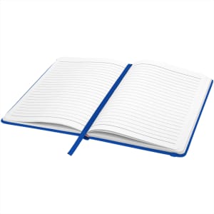 An A5 hard cover notebook with a blue cover and lined pages, featuring a ribbon bookmark and branding.