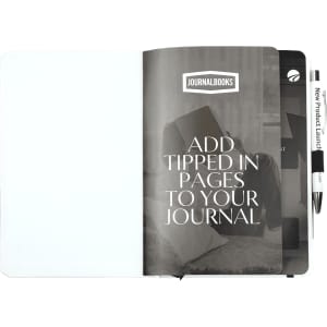 A white bound journal with coloured accents, featuring blank pages and a pen, open to reveal its inner contents.