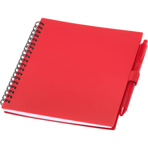 A red recycled polypropylene journal with a spiral binding and a matching red pen attached.