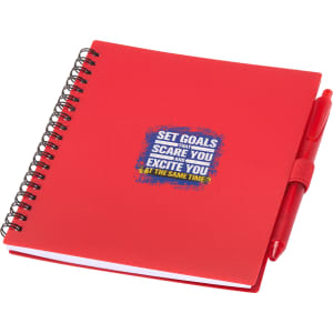 A red spiral-bound journal with a pen, featuring a branded design on the cover.
