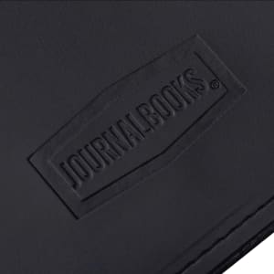 A black leather journal with a textured surface featuring a logo. The design is simple and elegant.