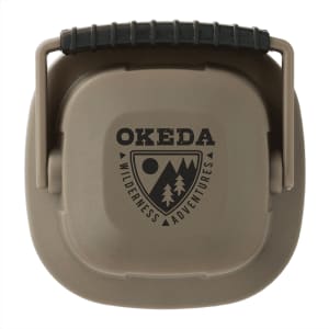 A compact, khaki-coloured mini camping lantern with a handle and a logo on the front.
