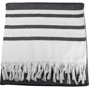 A Turkish beach towel displaying alternating dark grey and white stripes, featuring a fringed edge.