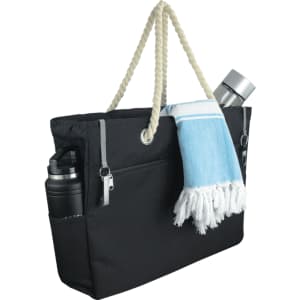A black waterproof beach bag with a rope handle, featuring a drink bottle, a towel, and side pockets.