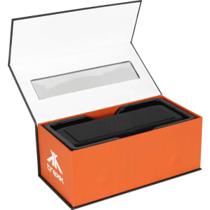 A black outdoor speaker and wireless power bank in an open orange box with a clear plastic window and branding.