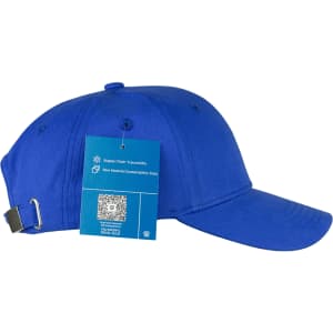 A blue organic cotton twill cap with an adjustable strap and a tag detailing material sustainability.