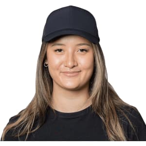 A navy Falcon Flex Cap displayed on a smiling woman with long, straight hair. The cap features a logo on the front.