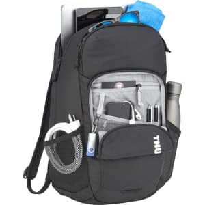 A black laptop backpack with multiple compartments, a drink bottle, sunglasses, and a towel. It features a logo.