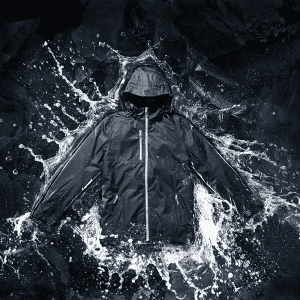 A men's rain jacket in black with a hood, featured against a splash of water. Includes a logo.