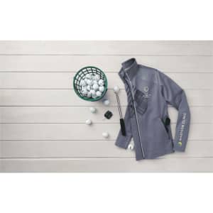 A grey full zip performance jacket with thumb holes and a logo, placed beside a basket of golf balls.