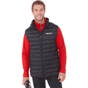 A man wearing a black insulated vest over a red long-sleeve shirt, holding a drink bottle. The vest has a logo.