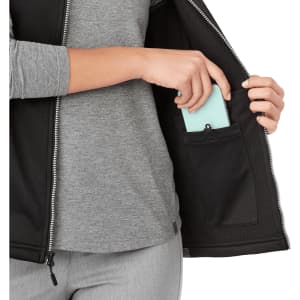 A black women's softshell vest with a zippered pocket, featuring a grey long-sleeve shirt underneath.