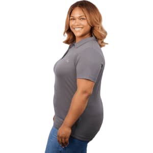A grey women's polo shirt with a fitted design, featuring a logo on the chest, displayed on a model.