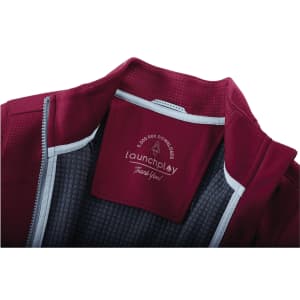 A maroon women's jacket with a full zip, featuring thumb holes and a lined interior. It has a logo on the inside.