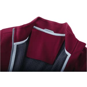 A maroon women's jacket featuring a full zip and thumb holes, with a textured interior lining and a logo.
