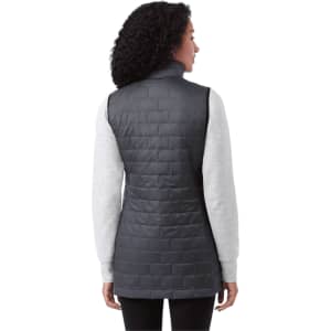 A woman wearing a dark grey lightweight packable insulated puffer vest, viewed from the back. The vest has a logo.