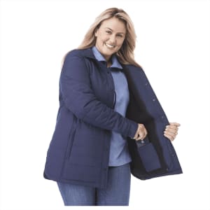 A navy insulated shacket with a zippered pocket, showcased by a smiling woman. It has a collar and buttons.