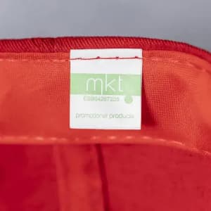A red promotional product with a green and white label featuring branding details.