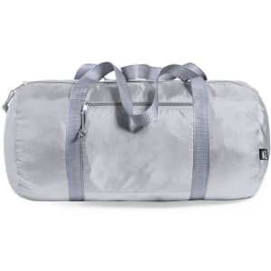 A silver duffle bag with two handles and a zipper, featuring a sleek, shiny surface. It has a logo on it.