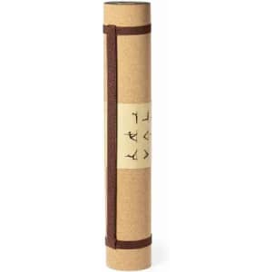 A yoga mat rolled up in brown cork, secured with a strap. It features a label with simple illustrations.