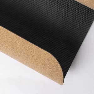 A textured black mat with a cork edge, featuring a wavy surface design.