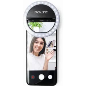 A smartphone with a ring light attached, featuring a young woman waving in front of a shelf. The phone has a branding logo.