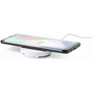 A wireless charger with a compact white base, featuring a smartphone resting on top, showing a charging indicator.