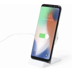 A smartphone with a partially charged battery sits on a white charging dock with a cable connected.