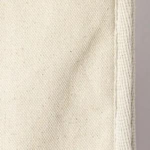 A piece of unbleached cotton fabric in a light cream colour, showing a textured surface and a stitched edge.