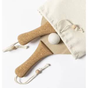 A cork paddle set with two paddles and a ball, neatly packed in a cream drawstring bag.