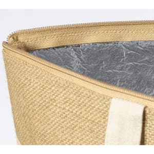 A bag with a textured, beige exterior and shiny silver interior, featuring a zip closure and canvas strap.