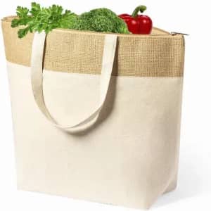 A tote bag featuring a natural fabric design, with a jute top section, filled with vegetables including broccoli and capsicum.