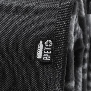 A textured black fabric with a small tag, featuring a logo and branding details.