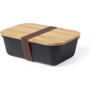 A lunch box with a black base and a bamboo lid, secured with a brown silicone strap.