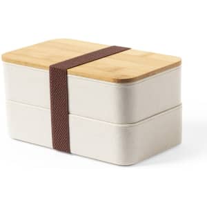 A bento box with a bamboo lid and a brown elastic strap, featuring a neutral colour.