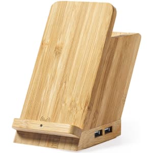 A bamboo phone stand with a slanted design and two USB ports at the base. It features a wireless charging area.