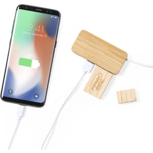 A wireless charger with a bamboo top and wooden base, connected to a smartphone displaying a charging icon.